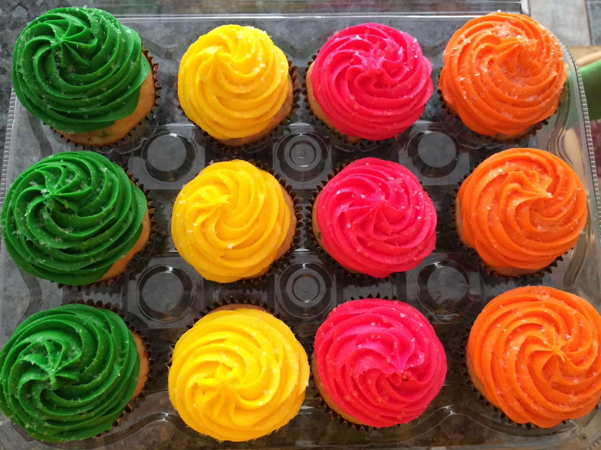 Pink frosted cupcakes in a pastel bakery box